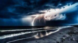 lighting in distance over ocean and sandy beach