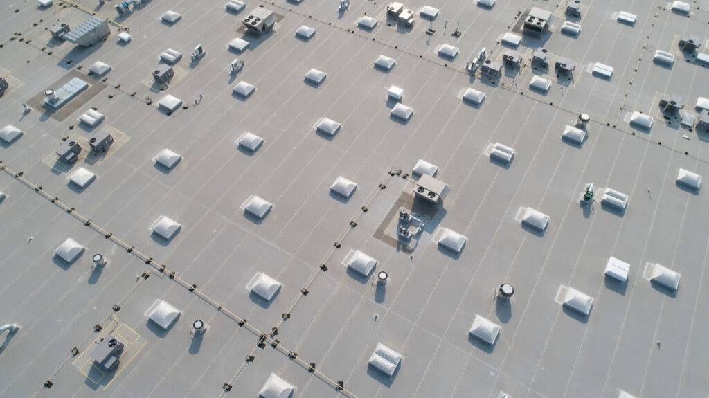 Aerial view of skylights and HVAC equipment on top of a commercial roof building