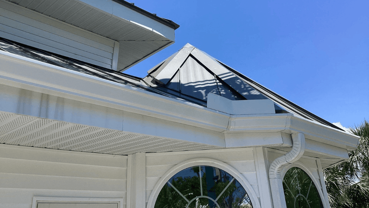 new white gutters on roof in florida, house with black roof and beautiful round windows