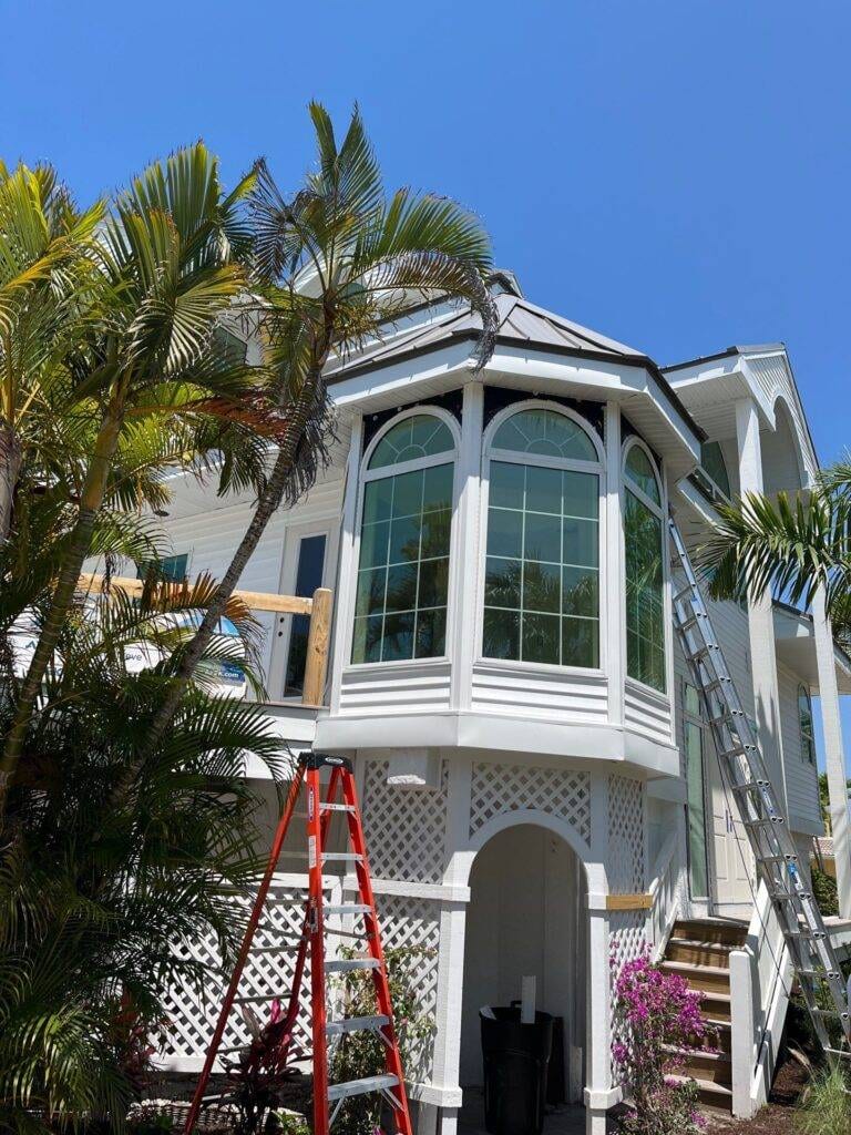 ladders against side of office building that looks like a home for gutter install