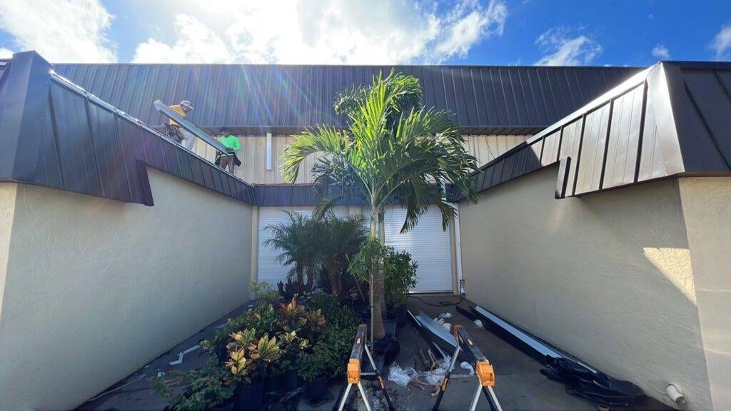 royalty roofers holding metal piece on roof during commercial roof replacement