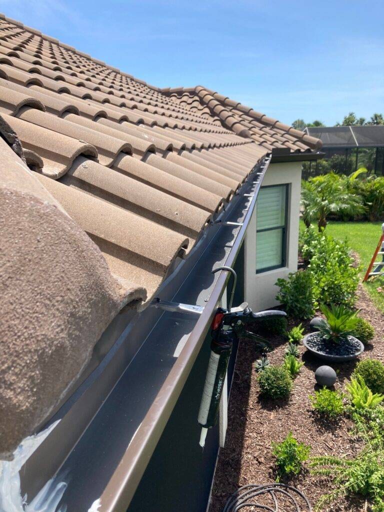 view of new gutter from roof on house with tile roof