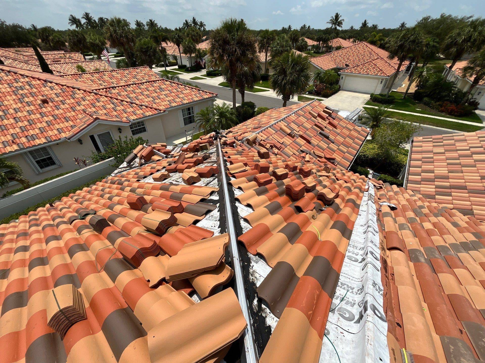barrel tile roof in process of replacement in suburb in naples florida surrounded by homes with the same brown to red colored tiles