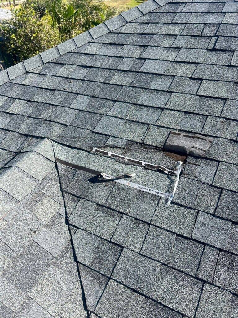 area on tile roof with damage needing repair, shingle tiles lifted from roof