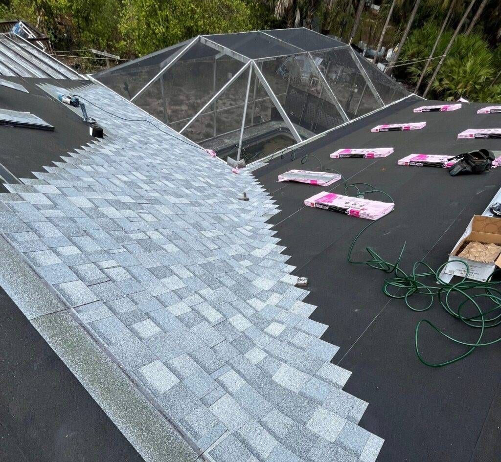 shingle roof replacement in process naples florida showing partially laid tiles and materials
