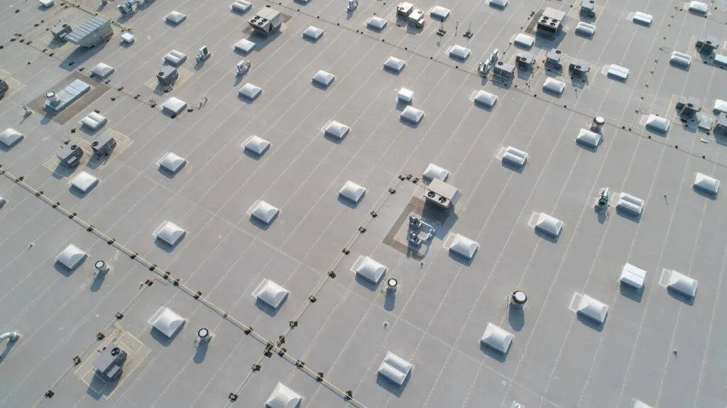 Aerial view of skylights and HVAC equipment on top of a commercial roof building