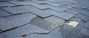 Close up view of bitumen shingles roof damage that needs repair.