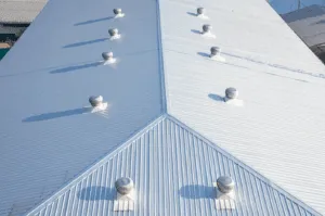Areal view of coating on white metal roof on a commercial building for protection from the elements