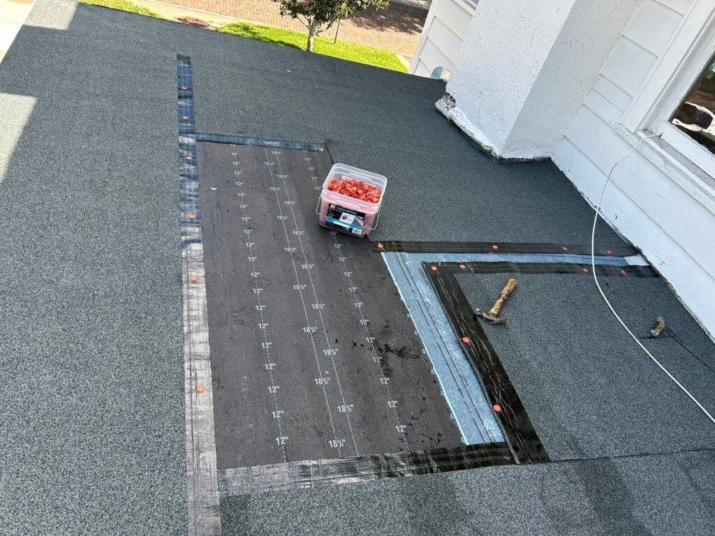 an asphalt roof showing the start of a roof repair with tools and underlayment