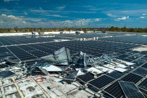 damaged solar panels on a flat roof after a storm