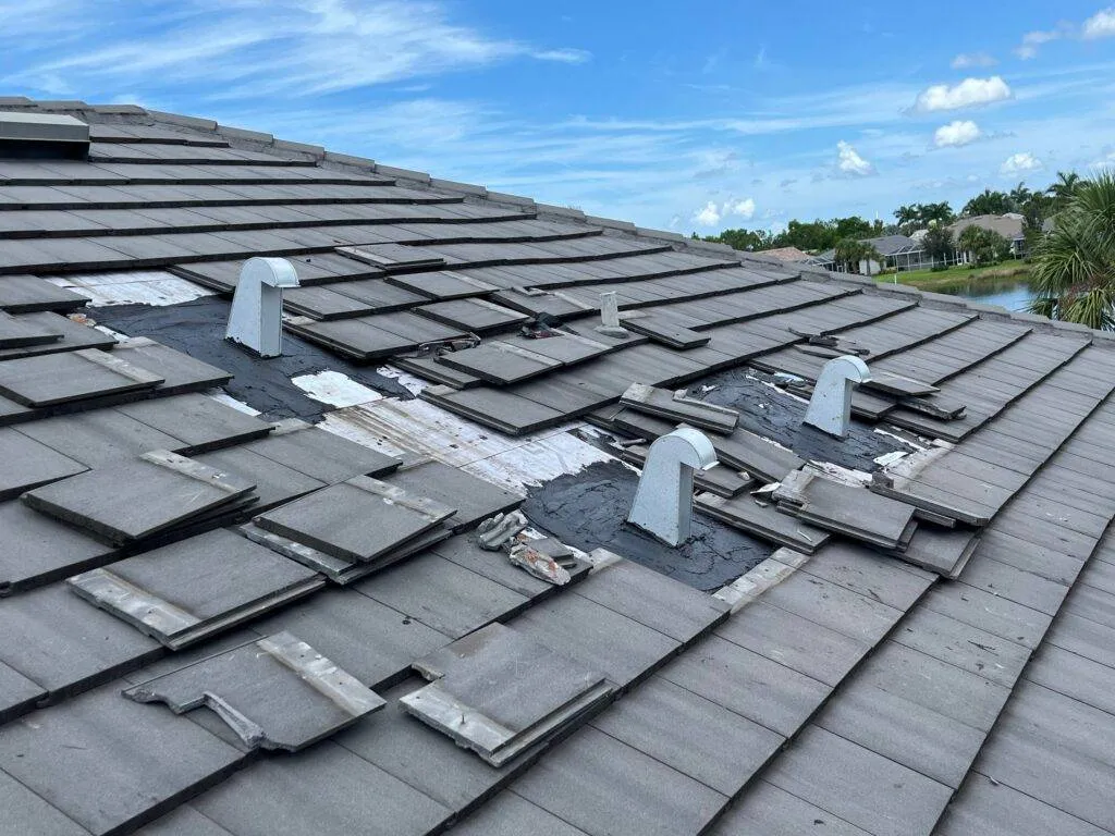 slate gray tile roof with panels missing