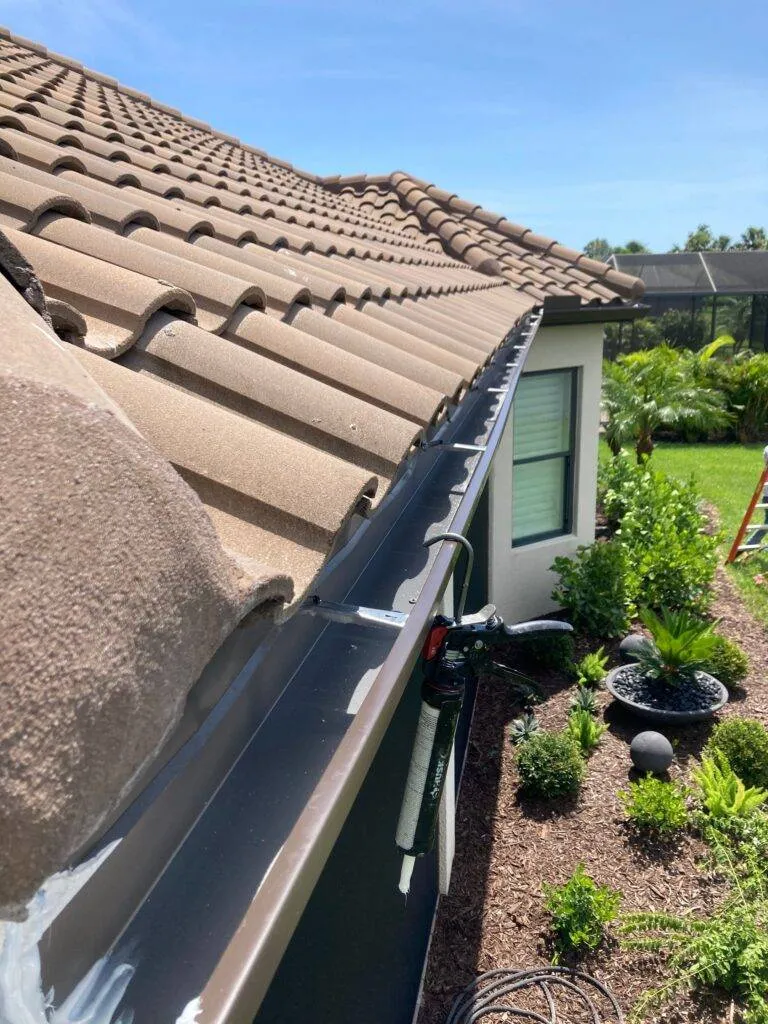 view of new gutter from roof on house with tile roof